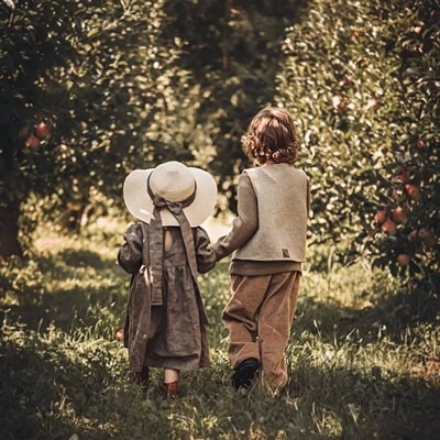 Das Foto zeigt zwei Kinder zwischen Apfelbäumen